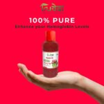 Hand holding Truveda Hemo G+ bottle with label promoting 100% pure findla juice to enhance hemoglobin
