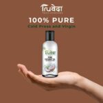 Hand holding a bottle of Truveda virgin coconut oil promoting purity and wellness, ideal for hair, skin, and cooking